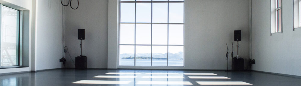 Konferanselokalet på Tou. Et stort rom med vinduer med utsikt mot fjord og fjell.